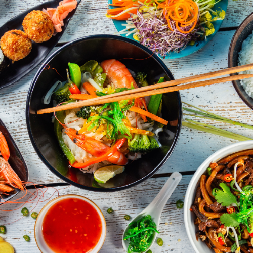 chinese food in dishes with chop stix