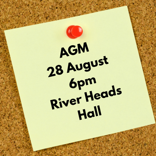 Yellow post it note pinned on cork board. Text says AGM 28 August, 6pm River Heads Hall